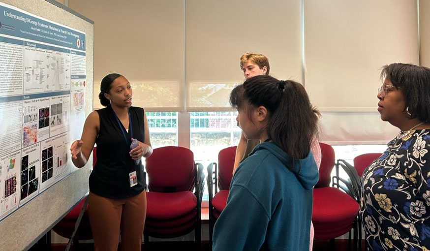 Alaya Chubb (left) presents her research at the NIDCR Summer Intern Poster Day