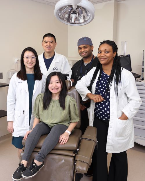 Clinical trial participant MinFen Lydia Foreman (seated) posed with members of NIDCR’s clinical team (from left to right), physician assistant Rachelle Chung, Drs. Ling Ye and Ayodeji Awopegba, and research nurse Danielle Elangue, at a recent visit.