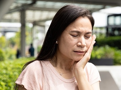 A woman experiencing mouth pain
