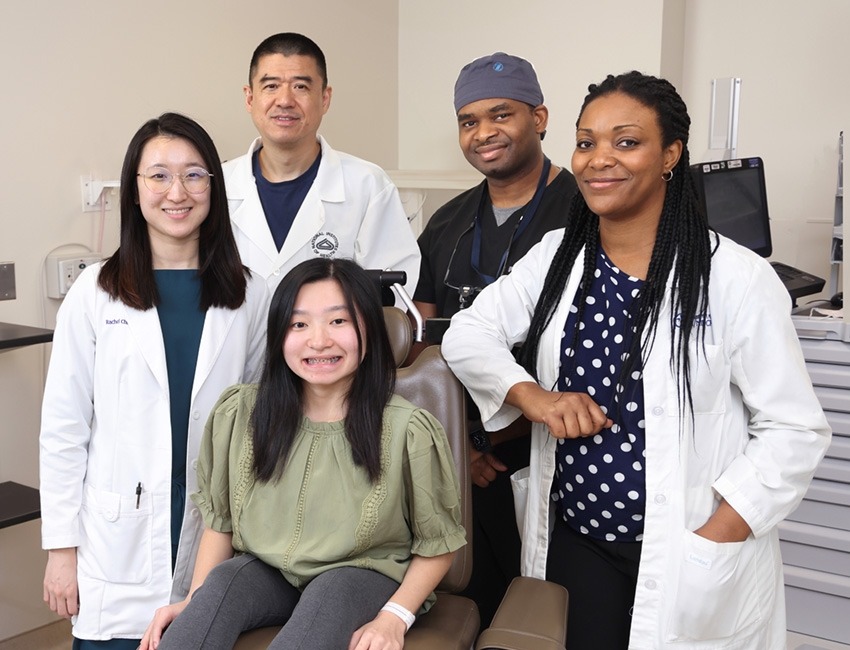 Clinical trial participant MinFen Lydia Foreman (seated) posed with members of NIDCR’s clinical team (from left to right), physician assistant Rachelle Chung, Drs. Ling Ye and Ayodeji Awopegba, and research nurse Danielle Elangue, at a recent visit. 