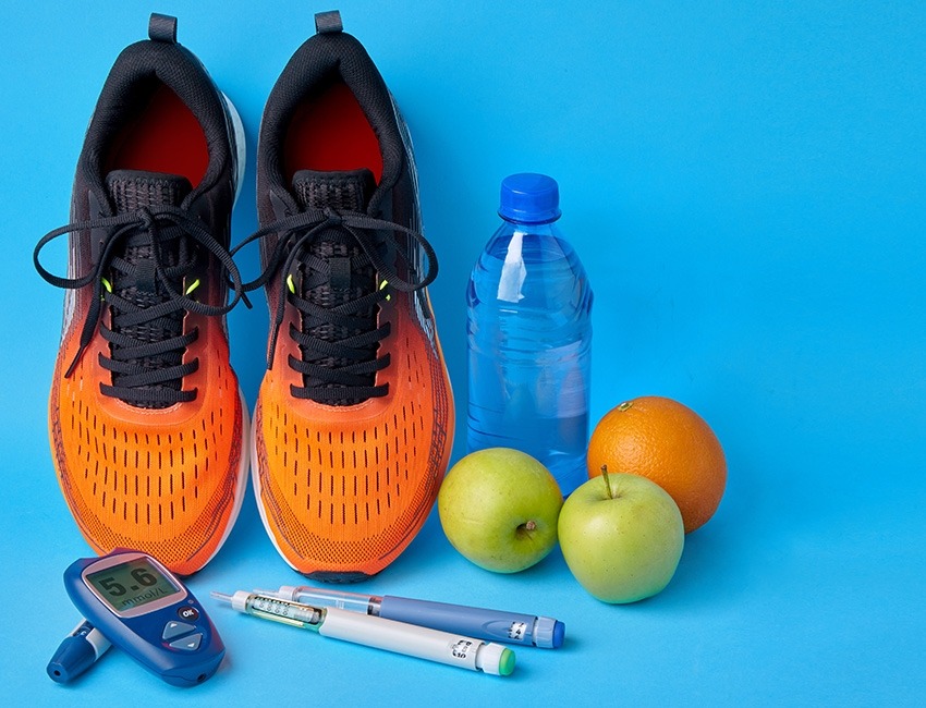 A pair of running shoes, fruit, and glucose monitoring equipment.