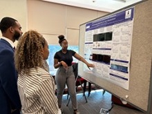 NIDCR summer student presenting her poster to an audience.