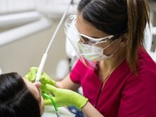 A dental clinician caring for a patient in the dental chair.