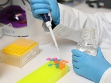 A scientist holding a pipette doing experiments.