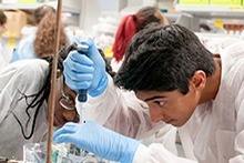 Two students in lab coats collaborating on a project in a laboratory.