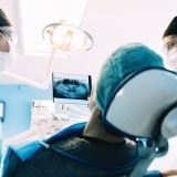 Two dental professionals with a patient in a dental chair